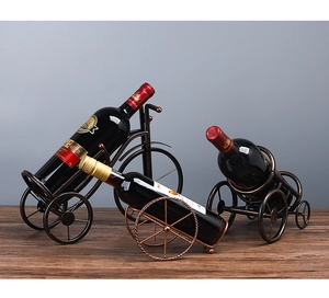 Detail van vintage bronzen wijnhouders in de vorm van een fiets en kar op een bureau