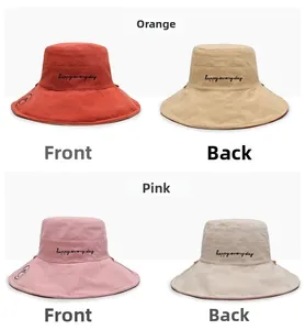 Detailed view of reversible sun hat showing smiley face print and happy everyday embroidery