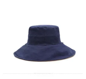 Detail view of navy blue sun hat with wide brim and brown contrasting edge trim