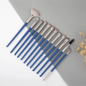 Gros plan sur un ensemble de 12 pinceaux à paupières avec manches bleus et poils souples
