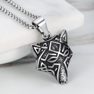 Detail of Viking wolf head pendant with Nordic totem patterns on white marble