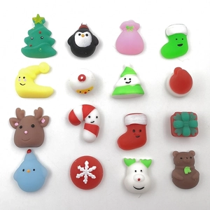 Flat lay of 16 mini TPR Christmas squishy toys including reindeer and snowmen on white