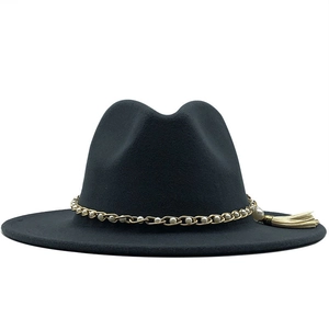 Close-up of black wool Fedora featuring a gold pearl chain and beige tassel detail