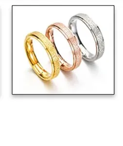 Detalle de anillos de acero inoxidable tricolores con acabado de arena esmerilada en oro y plata