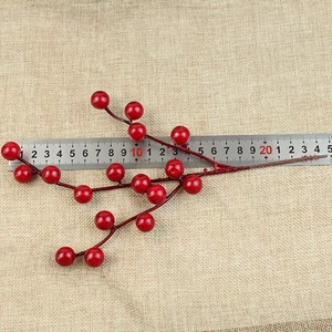 Detail of a 25cm artificial red berry stem with 16 glossy foam berries on a burlap surface