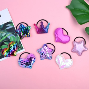 Close-up of sequin heart and star hair ties in gradient pink and purple tones