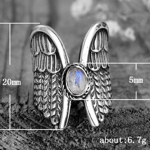 Vintage angel wing ring in antique silver with moonstone set on rustic wood surface