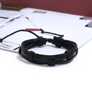 Detail shot of a black braided leather bracelet for men on a minimalist magazine background