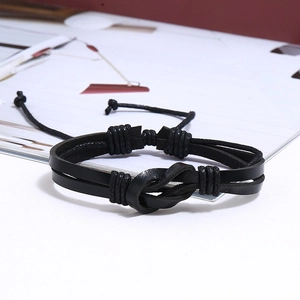 Detail of multi-layer black braided leather bracelet with central knot and adjustable cord