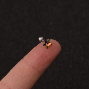 Macro detail of a star-shaped stud earring with rainbow crystal on a fingertip