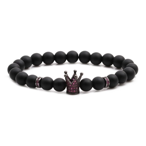 Close-up of matte black beads bracelet featuring a crown charm with pink stones