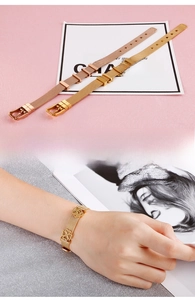 Détail du bracelet en maille réglable avec breloques trèfle et fleur en finition dorée