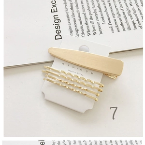 Detail of matte gold hair clip set with wavy metal bobby pins on display card