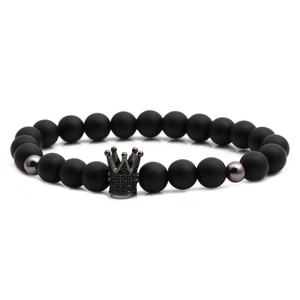 Detail of matte black stone beads and micro-pave crown charm on an elastic bracelet