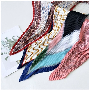 Detailed macro shot of pleated silk scarves featuring vintage chain and star patterns