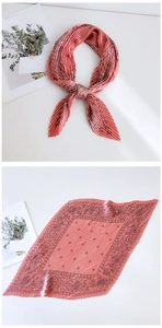 Close-up of pleated coral silk scarf with celestial star and vintage floral prints