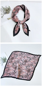 Close-up of pink and black paisley pleated silk scarf with wavy edges and elastic texture