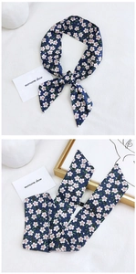 Detail of slim dark blue floral scarf showing delicate print and fabric texture