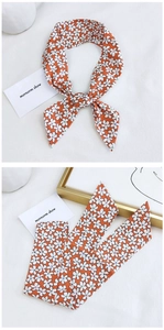 Close-up of orange floral skinny scarf with small white flower pattern for hair or bags