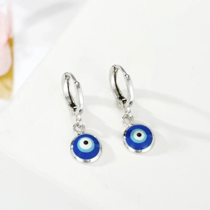 Silberne Creolen mit Evil Eye Anhängern und blauer Emaille auf weißem Hintergrund