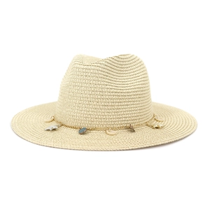 Detalle de sombrero de paja con cadena dorada y colgantes de concha y estrella de mar