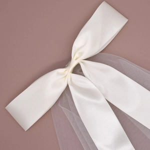 Elegant bridal short veil featuring a satin bow and delicate tulle in creamy white