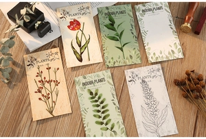 Detail of PET stickers featuring botanical designs on a warm wood desk with retro decor