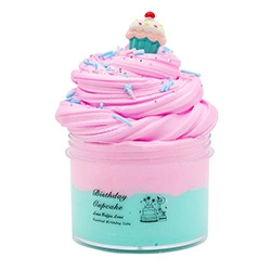 Macro view of pink and blue layered butter slime with birthday cupcake charm and sprinkles