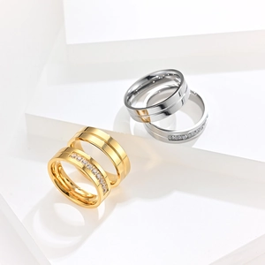 Detail of 18K gold and silver plated titanium steel couple rings with cubic zirconia inlay