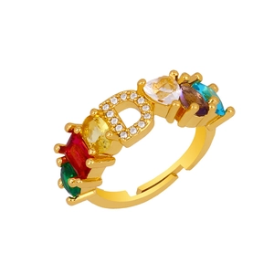 Macro detail of adjustable gold-plated ring with crystal D letter and multicolor gemstones