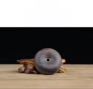 Macro detail of a 50mm ebony wood safety buckle on a carved base with natural grain
