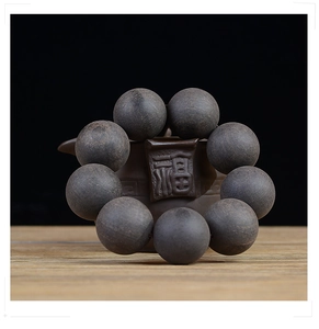 Macro detail of 20mm raw ebony wood beads on a teapot with elegant zen lighting