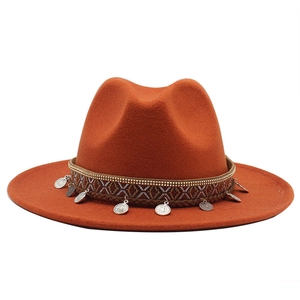 Detail of caramel fedora hat featuring bohemian jacquard ribbon and metal coin charms