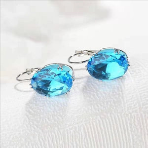 Detail of silver drop earrings with oval sky blue gemstones and fine faceted cutting