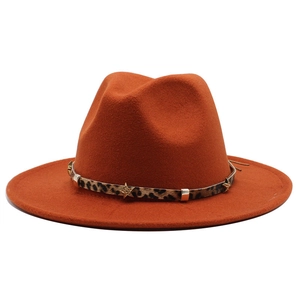 Detail of orange fedora hat featuring a leopard print band with gold star studs