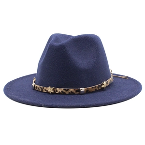 Detail of dark blue fedora with leopard band and gold star metal rivets on white background