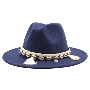 Close-up of navy wool felt hat featuring bohemian shells and tassel braided band details