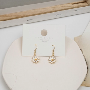 Macro detail of daisy drop earrings with silver posts on a vintage aesthetic background