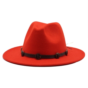 Detail of red wool fedora hat featuring a brown leather band and vintage round buckles