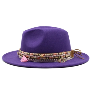 Detail view of purple wool fedora with bohemian fringe and shell pendant decorations