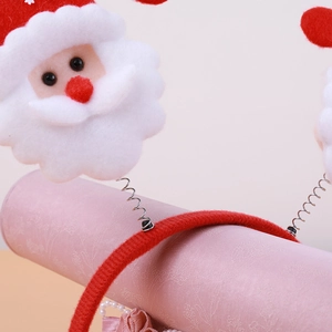 Christmas headband with Santa Claus spring dolls on a red fabric wrapped band for holidays