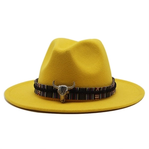 Detail of yellow wool fedora hat featuring ethnic woven band and silver bull head charm