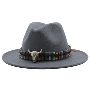Detail of dark grey wool fedora hat featuring ethnic woven band and silver bull skull accent