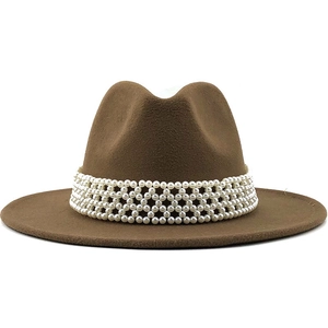 Détail d'un chapeau fedora en laine marron foncé avec bande de perles sur fond blanc