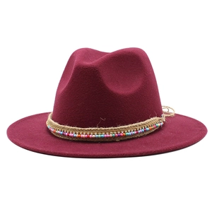 Close-up of burgundy wool fedora featuring bohemian beads and braided rope details
