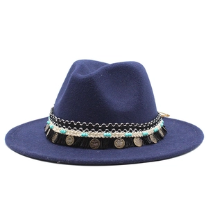 Dettaglio cappello di lana blu navy con fascia etnica e nappe stile vintage