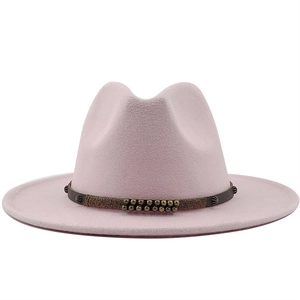Detail of light pink wool fedora hat with brown leather band and gold rivet accents