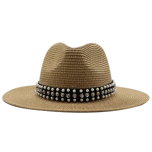 Détail d'un chapeau de paille avec bandeau élégant orné de perles et de strass