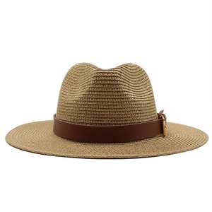 Detailed macro view of woven straw sun hat texture with brown leather belt and buckle