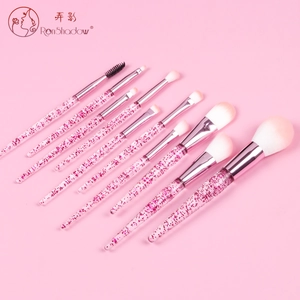 Close-up of pink glitter sequins inside acrylic handles of synthetic makeup brushes